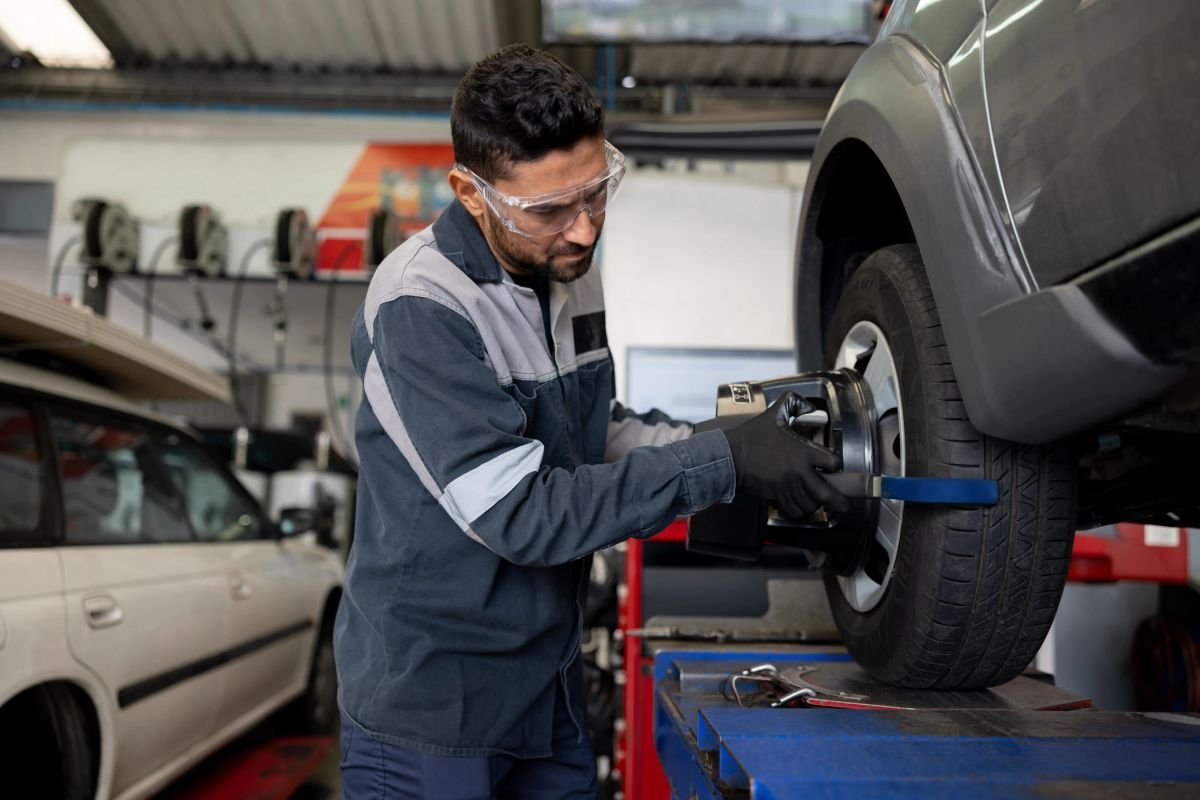 A mechanic balancing a tire at a car garage.